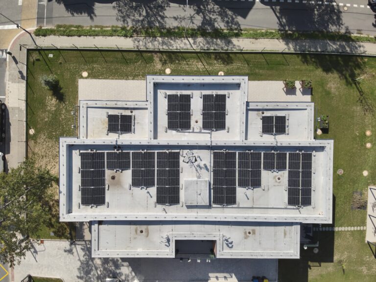 Pohled na střechu objektu s fotovoltaickými panely.